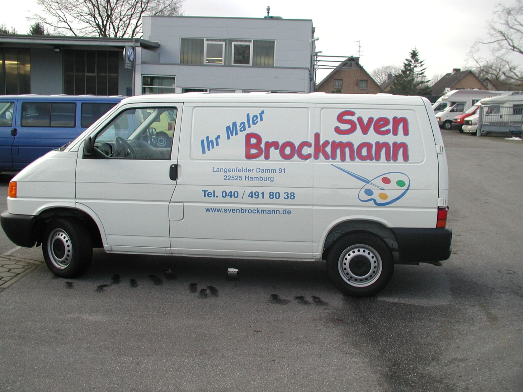 Weißer Transporter steht geparkt vor einem Gewerbegebäude, Seitenwand zeigt Firmenbeschriftung und Maler-Palette; auf der Seitenwand steht: Ihr Maler Sven Brockmann Langenfelder Damm 91 22525 Hamburg Tel. 040 / 491 80 38 www.svenbrockmann.de