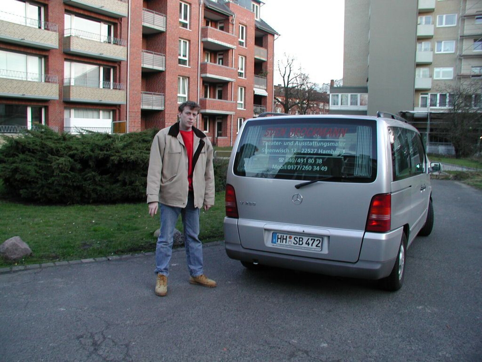 Mann steht neben silbernem Mercedes-Van (Kennzeichen 