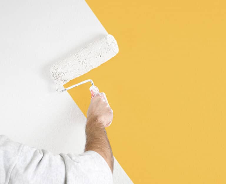 Mann streicht Wand gelb